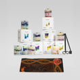 Load image into Gallery viewer, Collection of candles and packaging on a gray background
